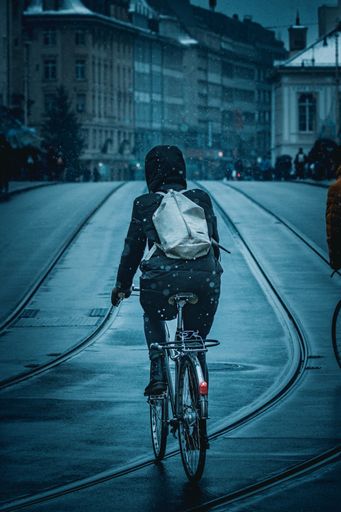 A person riding a bike in the snow over a bridge in Basel, Switzerland.