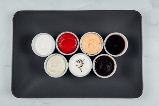 A high angle shot of small bowls filled with different flavored sauces on a table