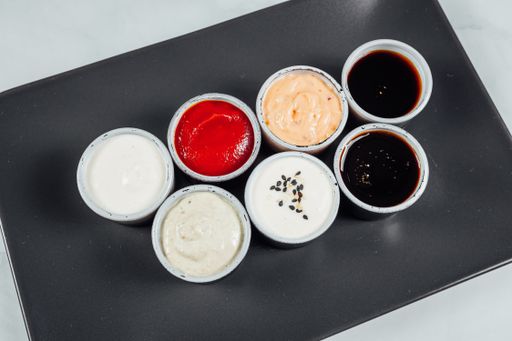 A high angle shot of small bowls filled with different flavored sauces on a table