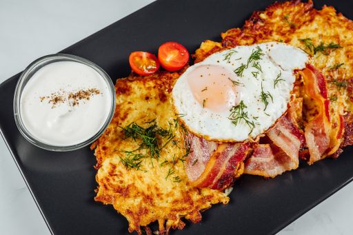 A high angle shot of a plate of delicious bacon and eggs on a table