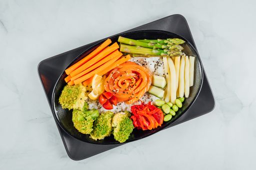 A high angle shot of a plate with fried rice and fresh vegetables