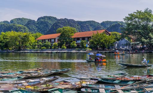 A scenic view of traditional boats on the river in the town of Tam Coc near Ninh Binh, Vietnam