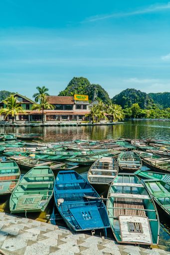 A vertical shot of traditional boats on the river in the town of Tam Coc near Ninh Binh, Vietnam