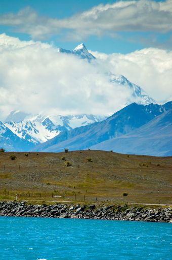 A vertical shot of clouds over Mount Cook with a hydro canal in the foreground in New Zealand