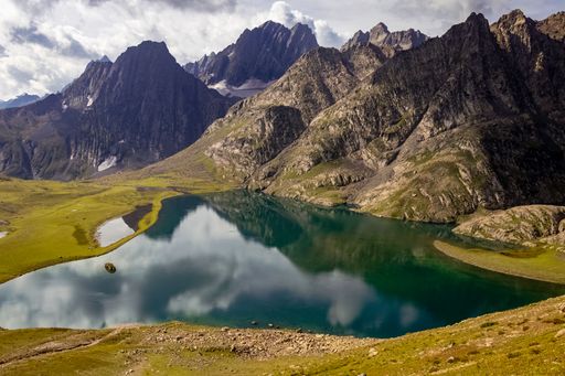 An awe-inspiring view of a mountain range with the serene Vishansar Lake in the foreground