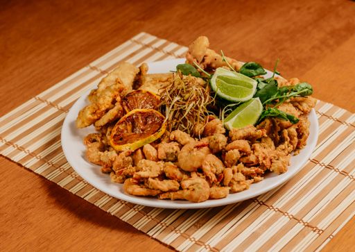 A shallow ceramic plate with a variety of fried food