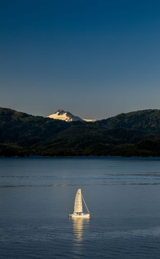 A vertical shot of a yacht in the middle of the lake