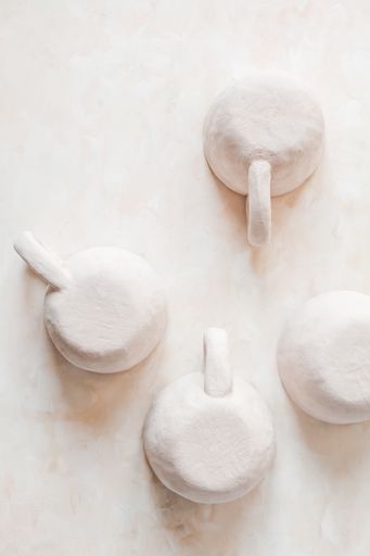 A vertical top view of small handmade crafts beige clay pottery cups with handles