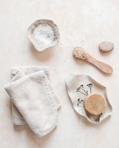A vertical top view of plastic-free zero waste bathroom supplies for personal hygiene