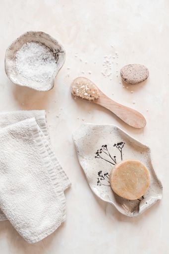 A vertical top view of plastic-free zero waste bathroom supplies for personal hygiene