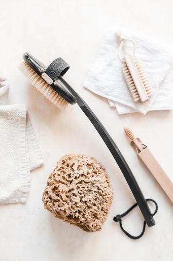 A vertical top view of plastic-free zero waste bathroom supplies for personal hygiene