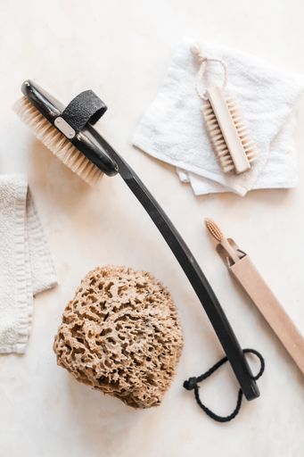 A vertical top view of natural plastic-free zero waste bathroom supplies for personal hygiene