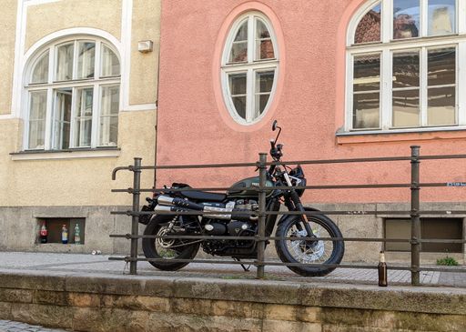 The Triumph Scrambler motorcycle parked in front of a building in Prague, Czech Republic