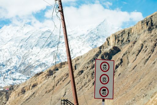 Road sign warning against slippery road due to snow ice