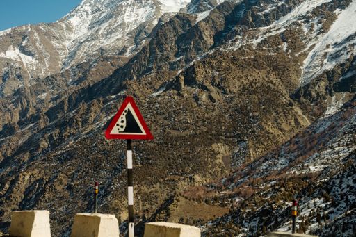 Road sign warning against slippery road due to snow ice