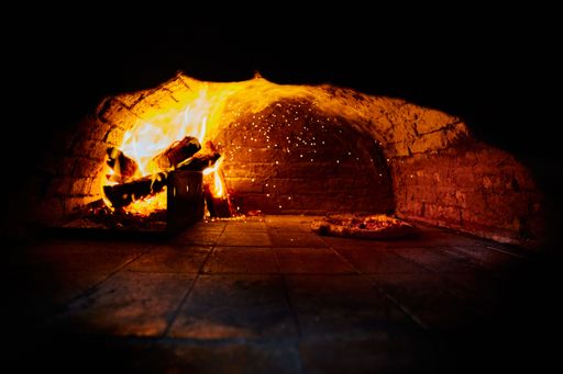 The pizza baking by the fire in an oven - Neapolitan oven pizza