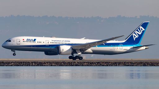 A white and blue airplane is taking off, with its landing gear fully deployed