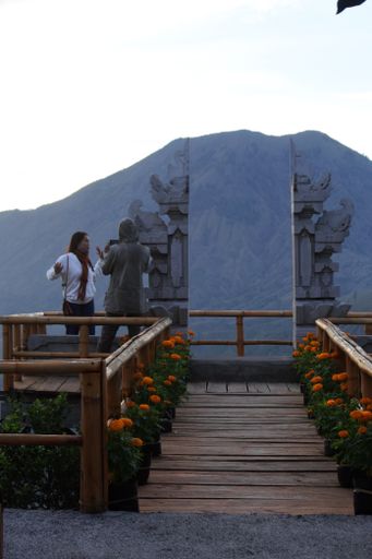 A couple of tourists taking selfies against the backdrop of Mount Batur in Kintamani, Bali, Indonesia, November 13, 2020