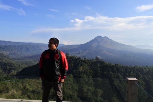 A couple of tourists taking selfies against the backdrop of Mount Batur in Kintamani, Bali, Indonesia, November 13, 2020