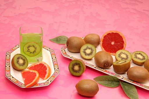 Kiwi and grapefruit on octagonal plates with colorful ornaments. Still life.