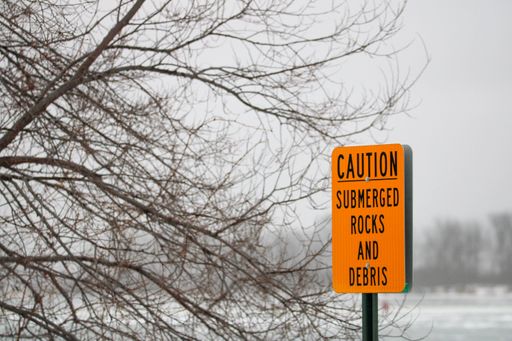 An orange caution sign on the snowy road