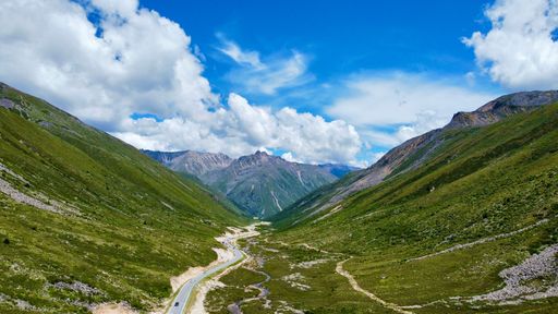 A narrow path passing through scenic green mountains