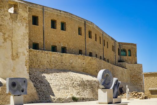 A scenic view of an old brick-walled building under a clear blue sky