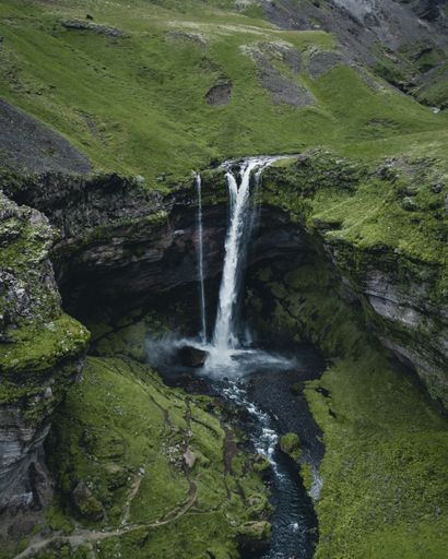 A breathtaking view of a powerful waterfall surrounded by rocky cliffs in Iceland
