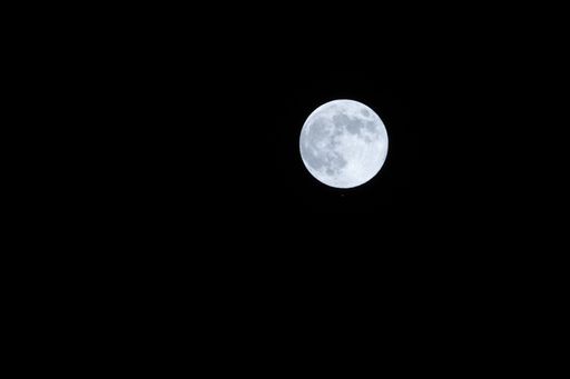 A stunning full moon illuminates the night sky, creating a captivating scene