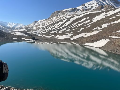 A landscape view of Suraj Tal Lake in Himachal Pradesh, India with snowy mountains