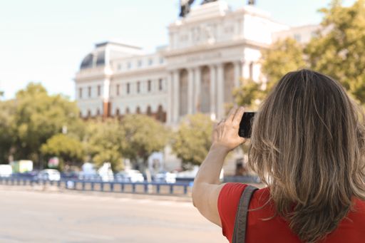 A back view of a female taking a photo of a landmark in Madrid