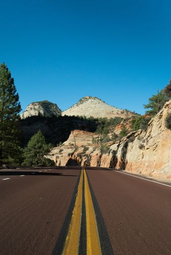 A vertical shot of a narrow road near the mountains