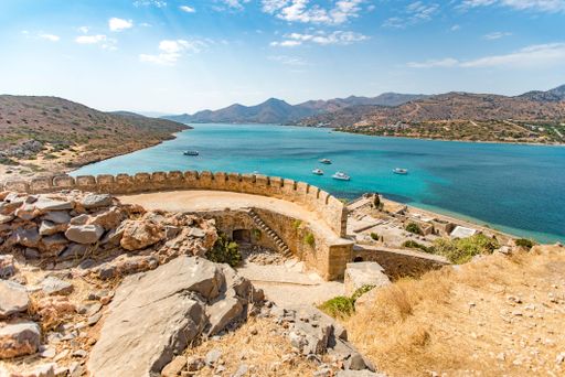 A scenic view of the sea with boats surrounded by majestic mountains. Lindos, Greece.