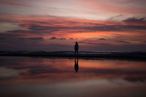 A woman's silhouette on Indaia Beach at sunset. Bertioga, Sao Paulo.