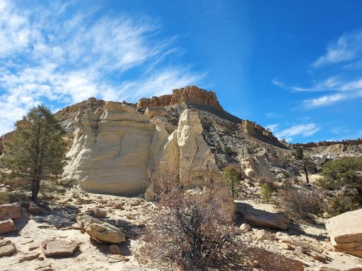 A natural geological formation stones with dry plants under blue cloudy sky on a sunny day