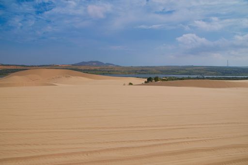 A scenic view of golden sand under a blue sky in a desert