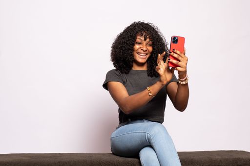 happy beautiful young black lady using her phone