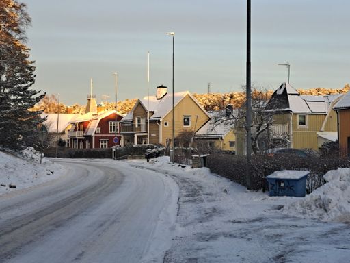 A road and houses covered in snow on the sunrise