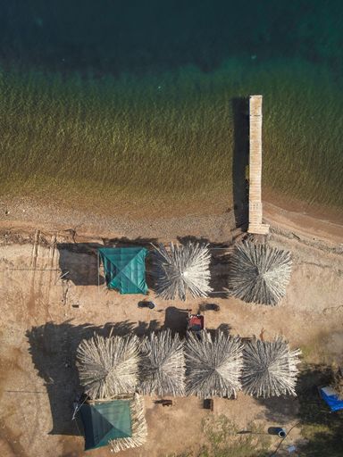 A vertical aerial view of a beach bar with a small wooden pier  in Perama,Lesvos,Greece