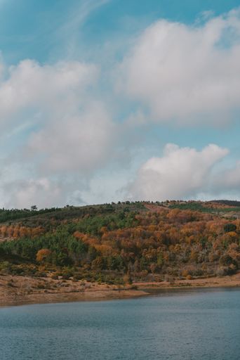 A beautiful lake surrounded by a mountain range under the breathtaking cloudy sky