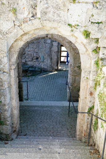 A high angle shot of the outdoor staircase descending through the stone arches, old architecture