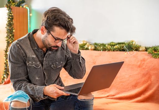 A handsome male working on his laptop while sitting on a couch