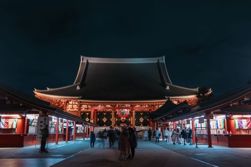 A scenic view of the illuminated Sensoji full of tourists at night in Asakusa, Tokyo