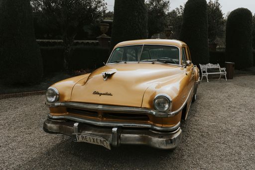 A vintage 1951 Chrysler Imperial resting in a picturesque garden setting.