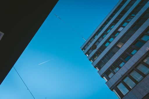 A low angle shot of tall buildings with a lot of windows under the clear sky
