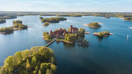 An aerial shot of the Trakai Island Castle in Lithuania surrounded by the lake on a sunny day