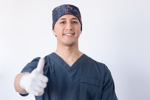 A portrait of a Hispanic dentist doing thumbs up