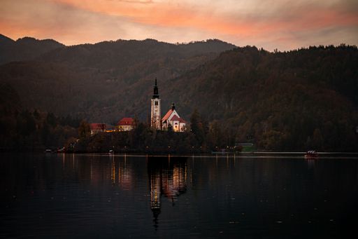 A picturesque sunset with the Bled castle with a tranquil lake in the foreground in Slovenia