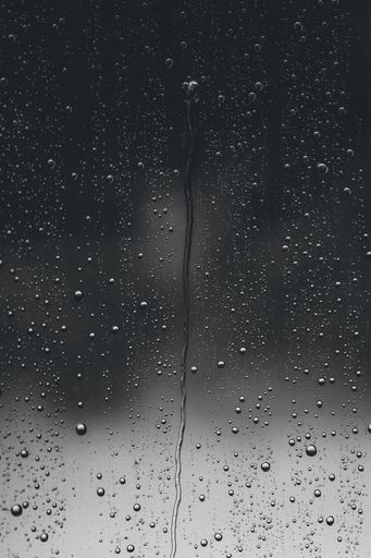 A beautiful vertical shot of water droplets on a window