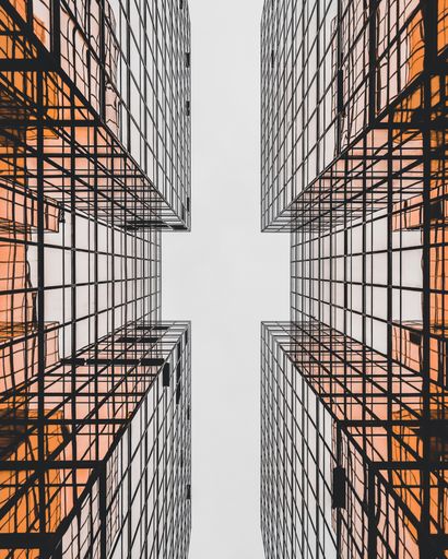A low angle shot of modern geometrical glass buildings making cross view, Honk Kong
